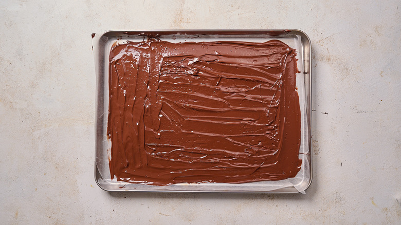 smoothing chocolate onto wax paper