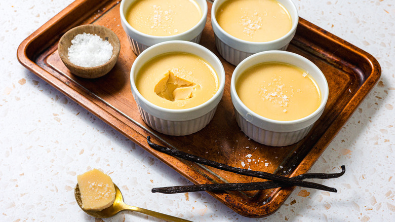 4 ramekins of salted caramel panna cotta with vanilla bean and salt