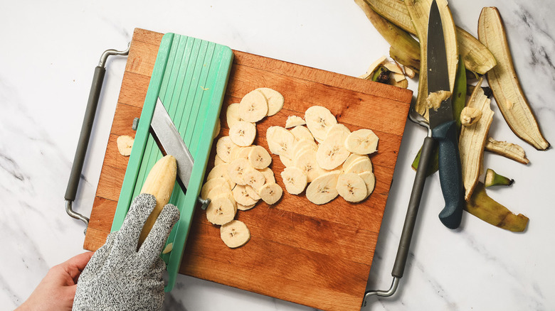 Slicing plantains on a mandoline slicer