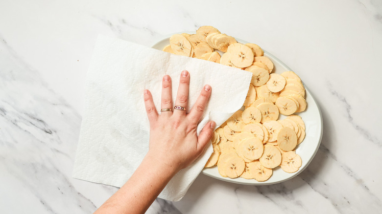 Patting plantains with paper towel