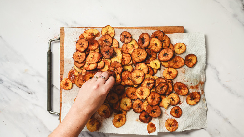 Sprinkling plantain chips with salt