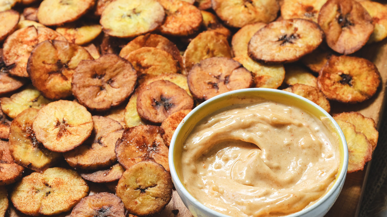 Board with plantain chips and sauce