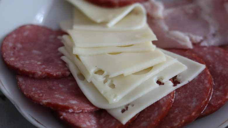 Slices of meat and cheese on plate.