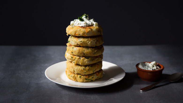 Stack on chickpea patties on plate with cucumber yogurt