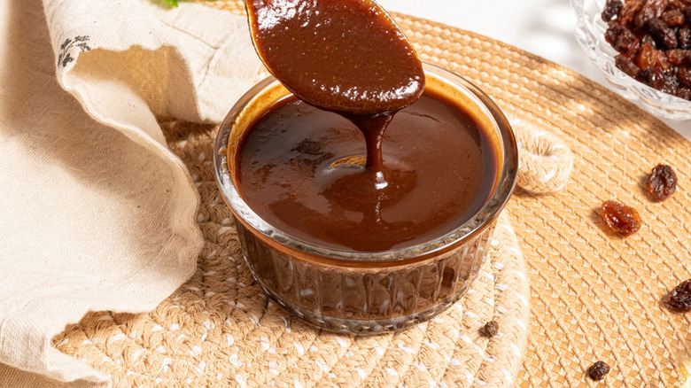 Spooning A.1. sauce from glass bowl