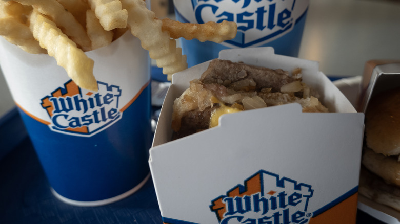 The White Castle slider in a box next to White Castle fries and drink