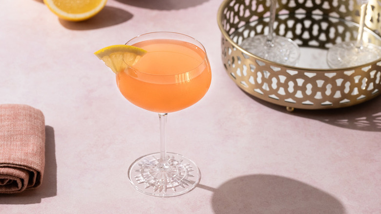 Grapefruit cocktail in long-stemmed glass, garnished with lemon slice