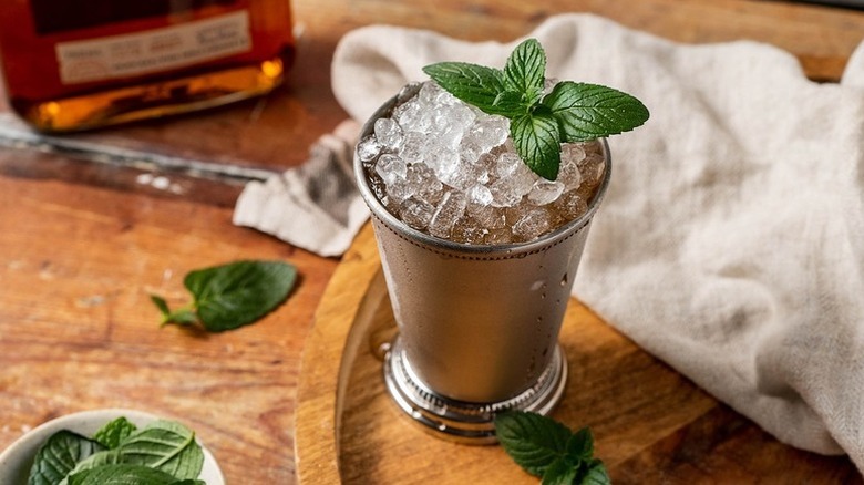 Mint julep cocktail in metal tumbler with crushed ice and fresh mint leaves