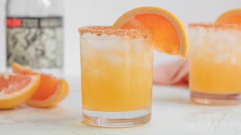 Paloma cocktail with chili salt rim and grapefruit wedge garnish