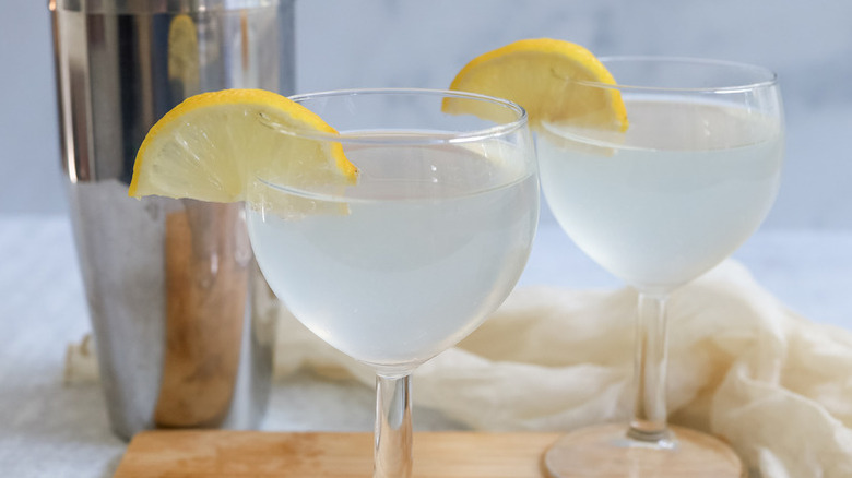 White tea shots in two glasses, each garnished with a lemon slice