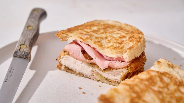 Cheesy Chicken Cordon Bleu Panini on white plate with knife
