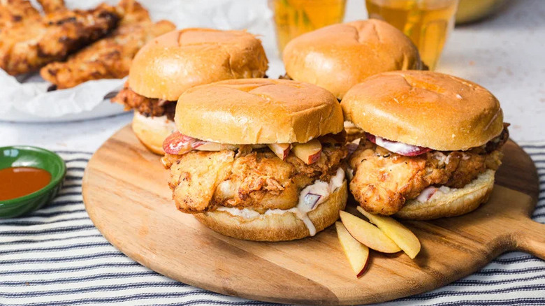 Crispy Peach Chicken Sandwiches on wooden cutting board