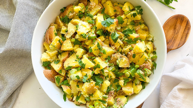 Bowl of potato salad, garnished with fresh parsley