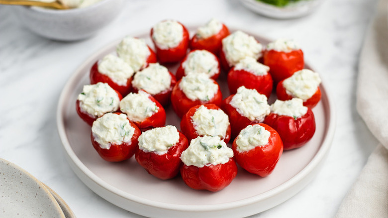 Cream cheese-stuffed cherry peppers on white plate