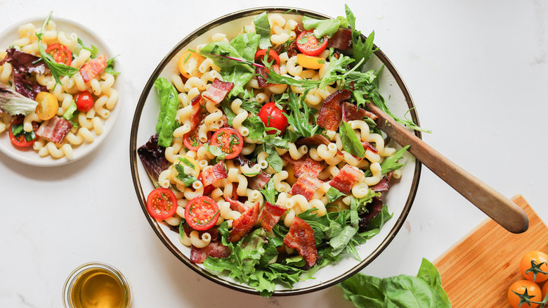 BLT macaroni salad in serving bowl with wooden spoon