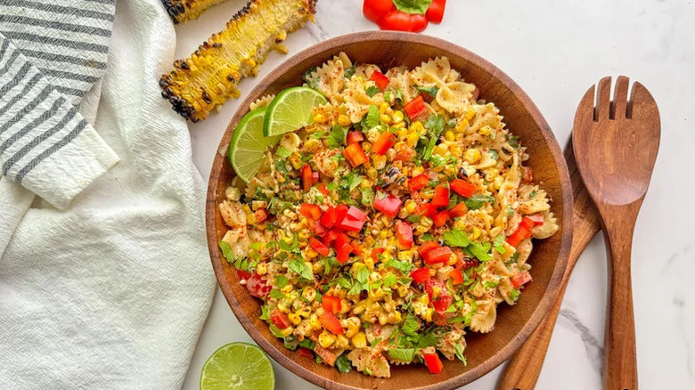 Charred Mexican Street Corn Pasta Salad in wooden bowl with wooden utensils