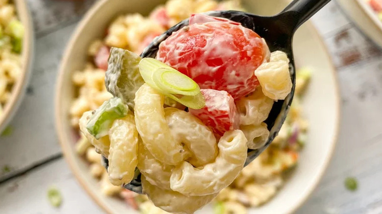 Creamy Macaroni Salad up close on black spoon
