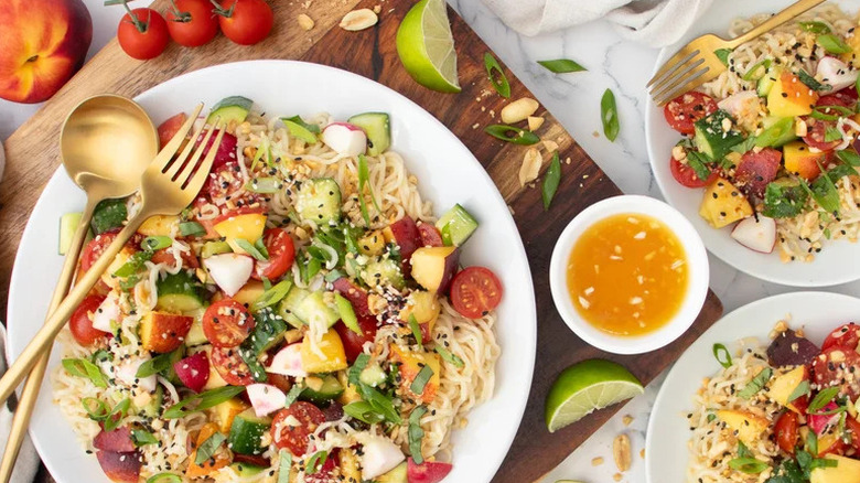 Peach and Tomato Cold Summer Ramen in white bowls with serving utensils