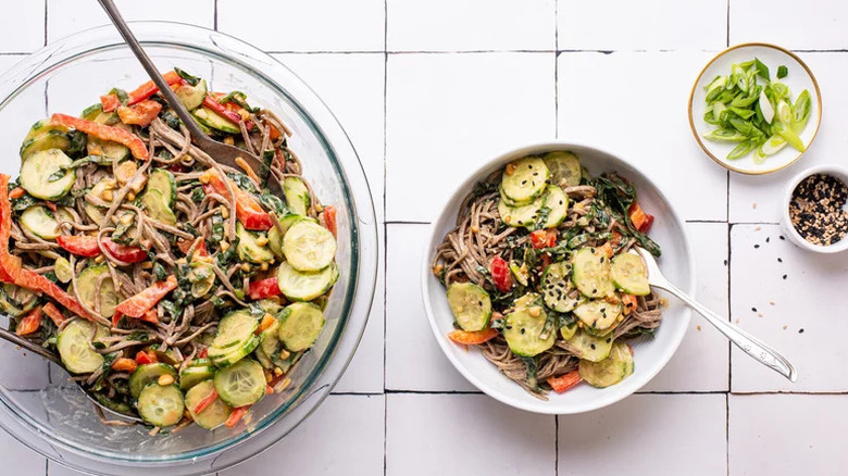 Peanut Soba Noodle Salad in bowls on white tile surface