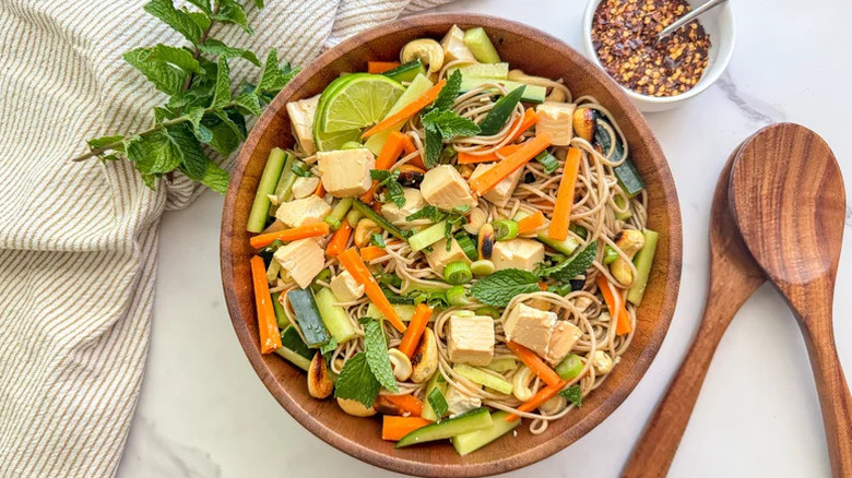 Silken Tofu and Soba Noodle Salad in large wooden bowl with herbs