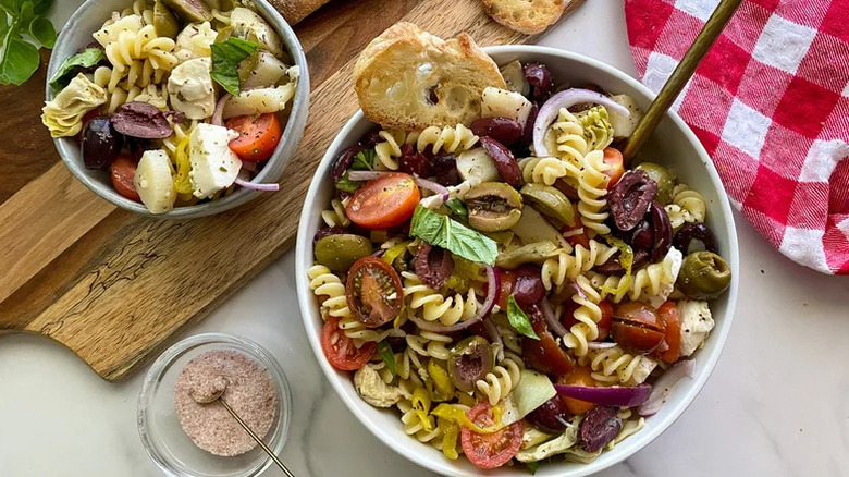 Veggie Antipasti Italian Pasta Salad in two white bowls with one on wooden board