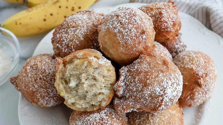 Coconut Banana Fritters stacked on white plate