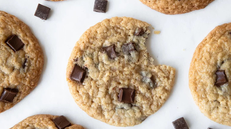 Coconut Chocolate Chip Cookie with bite out of it on white surface