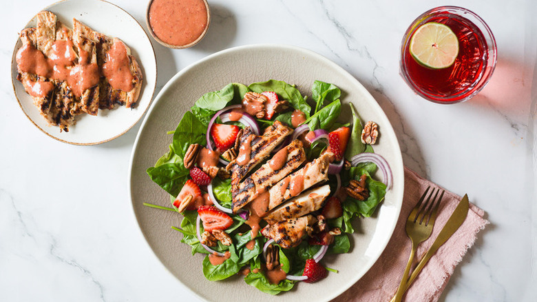 Bowl of chicken salad with strawberries and spinach