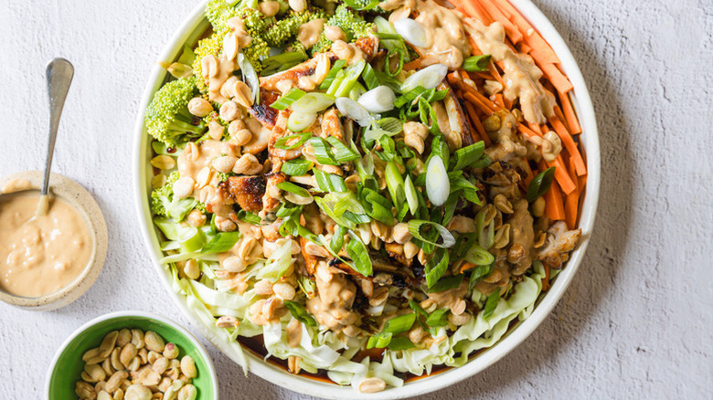 Bowl of teriyaki chicken salad topped with peanuts and green onions