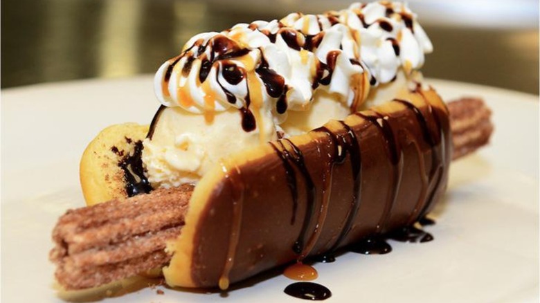 Churro dog with ice cream, whipped cream, and syrups