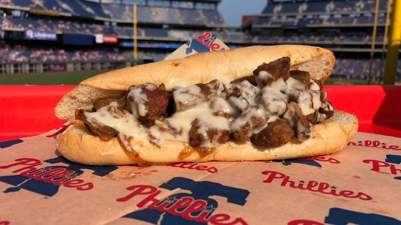 Burnt ends cheesesteak on Phillies paper with stadium blurred in background