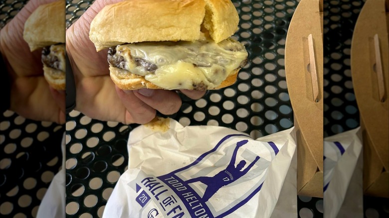 Hand holding cheesy burger with Todd Helton wrapper