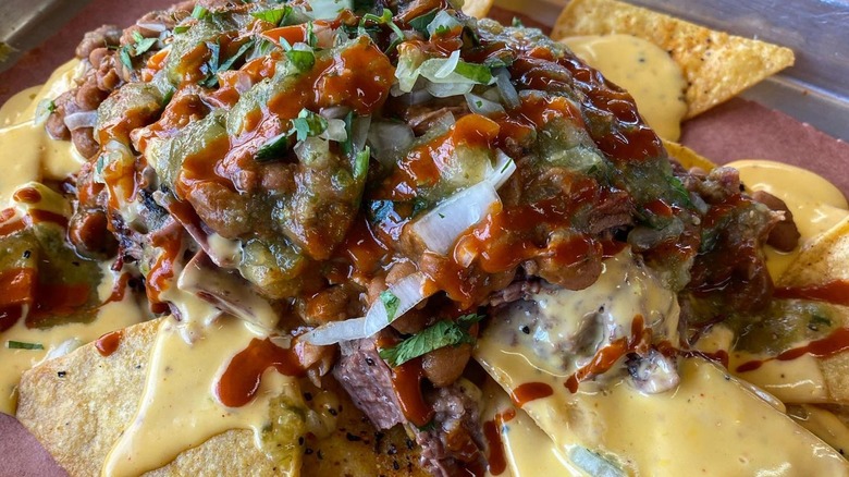 Brisket nachoes with cheese, onions, and salsas
