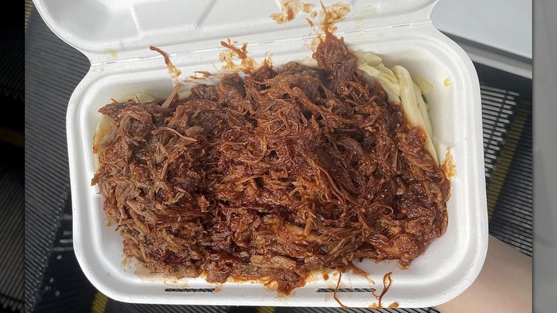 Pulled pork over pierogi in styrofoam container