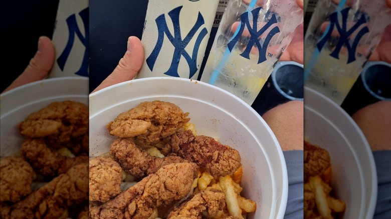 Chicken bucket with tenders and fries with drinks in background