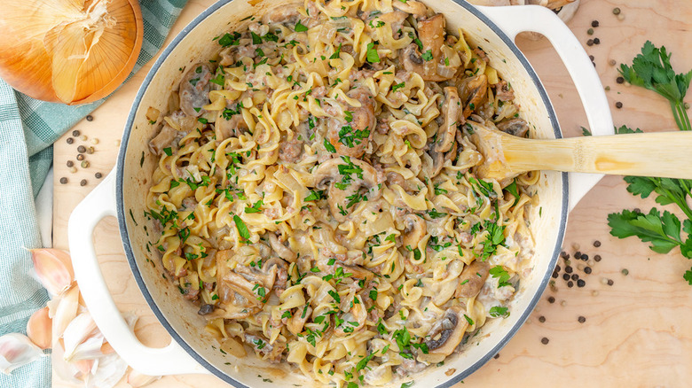 Ground beef stroganoff in casserole pot with wooden spoon