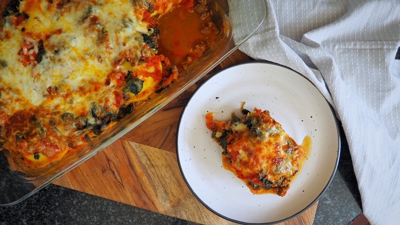 Spinach lasagna served from baking dish onto plate