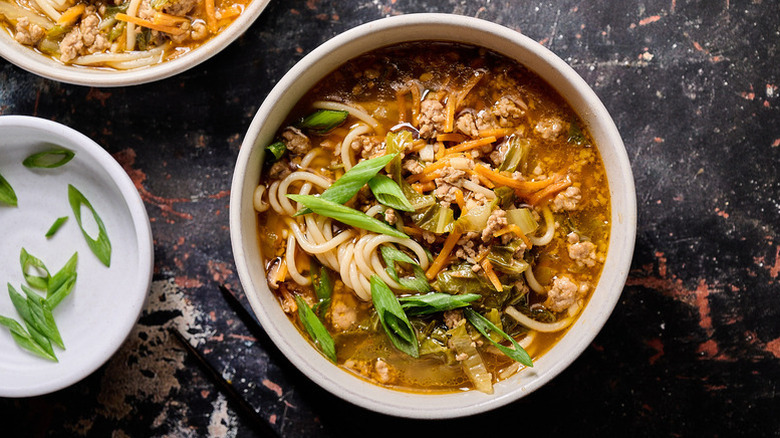 Bowl of "egg roll in a bowl" noodle soup topped with chopped green onion