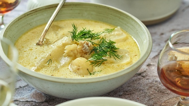 Bowl of fish and potato chowder, topped with fresh dill