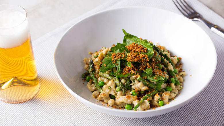 Bowl of rye spaetzle With asparagus, peas, and dandelion greens