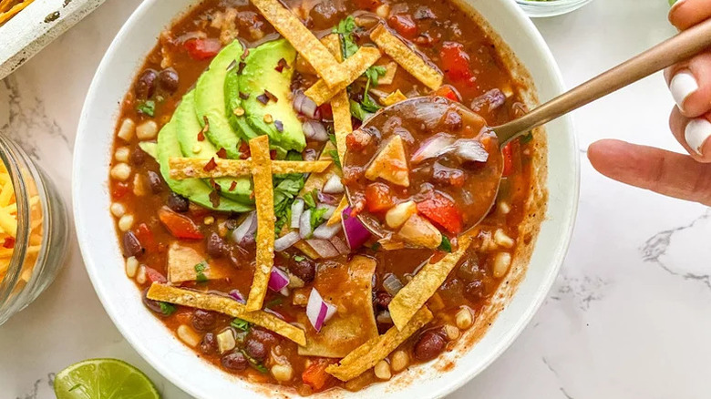 Hearty Vegetarian Tortilla Soup in white bowl with spoon