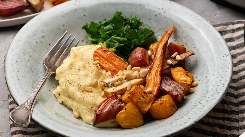 Roasted Root Vegetable Polenta in grey dish with kale