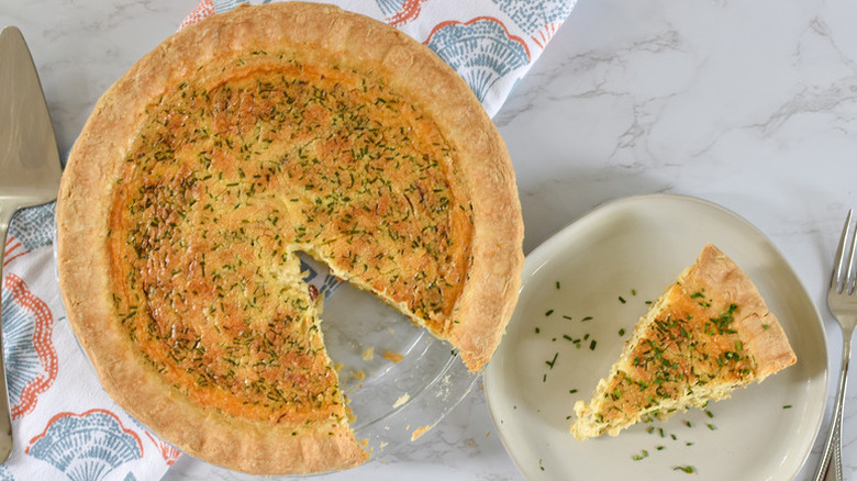 Quiche Lorraine in glass dish with slice served onto plate