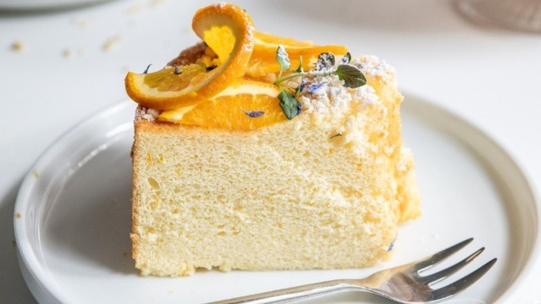Slice of orange chiffon cake on plate with fork