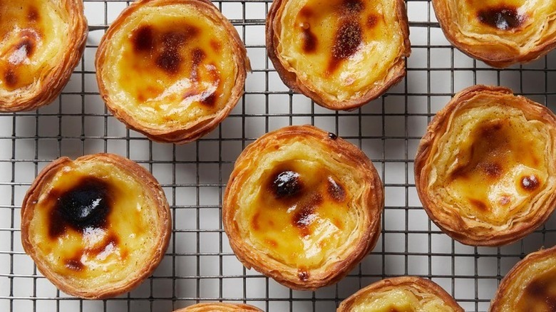 Portuguese egg tarts on wire cooling rack