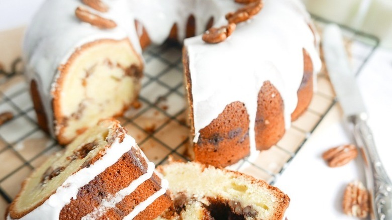 Glazed pecan bundt cake on wire rack, with slices taken out