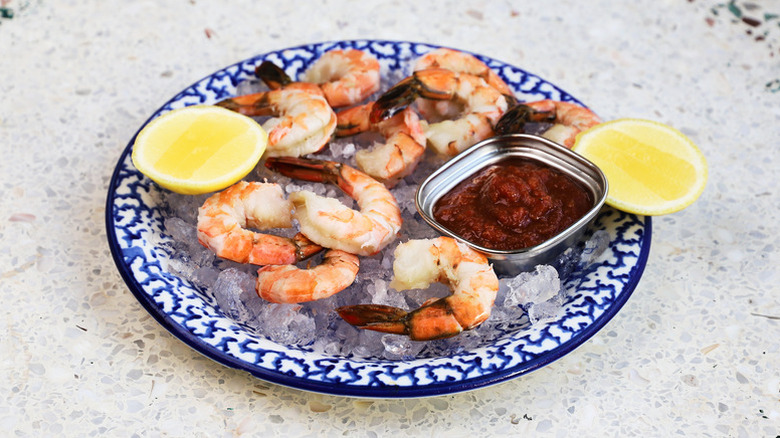 Shrimp cocktail served over ice on blue and white patterned plate