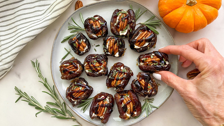 Pecan-stuffed dates on plate with sprigs of rosemary