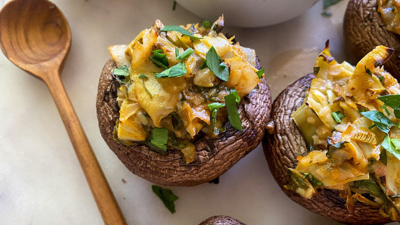 Close up of artichoke-stuffed mushrooms, garnished with chopped parsley