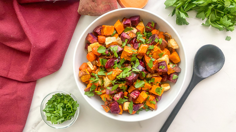 Root vegetable assortment in serving bowl topped with herbs